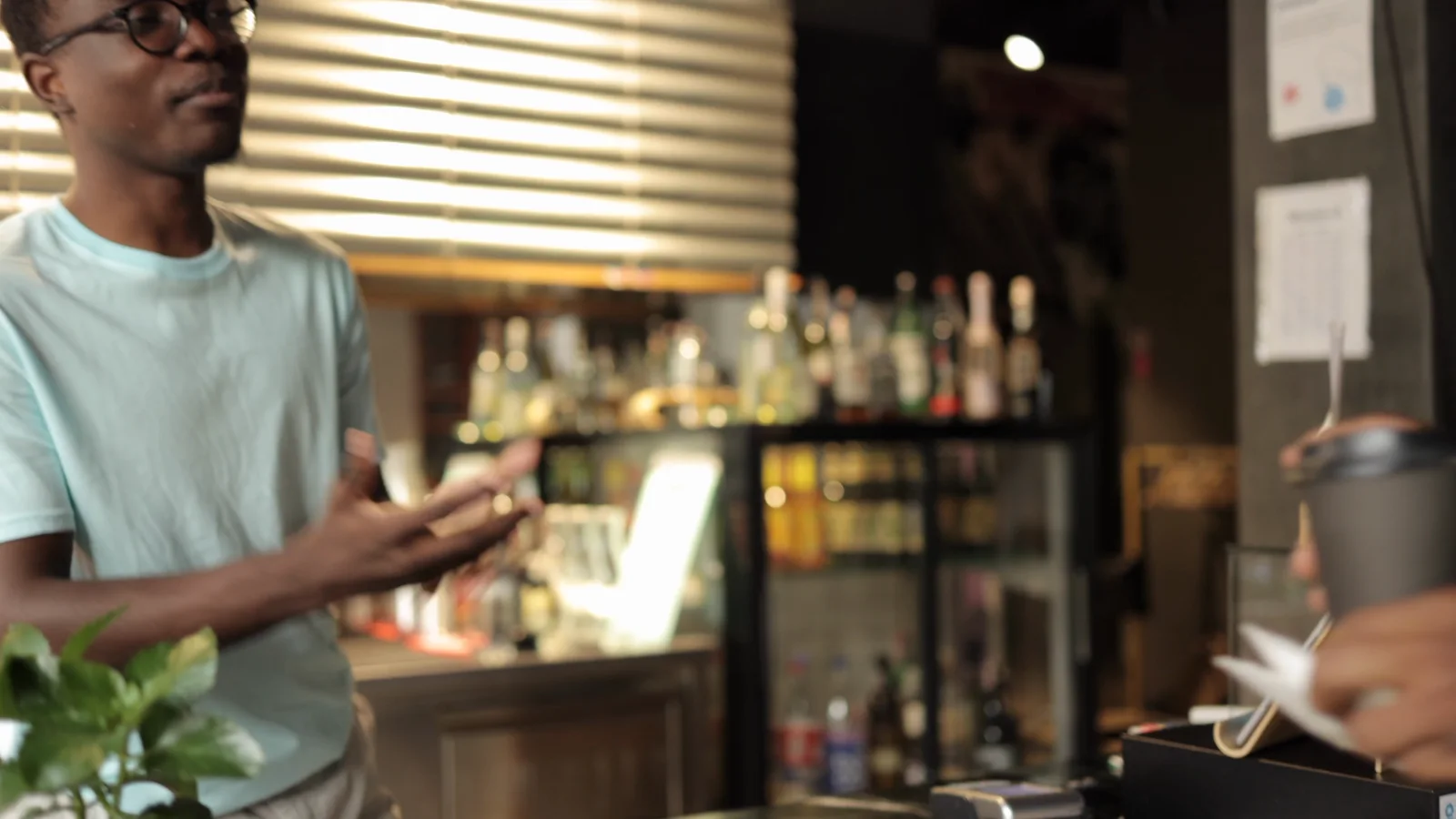 A customer speaking with a barista at the cafe counter